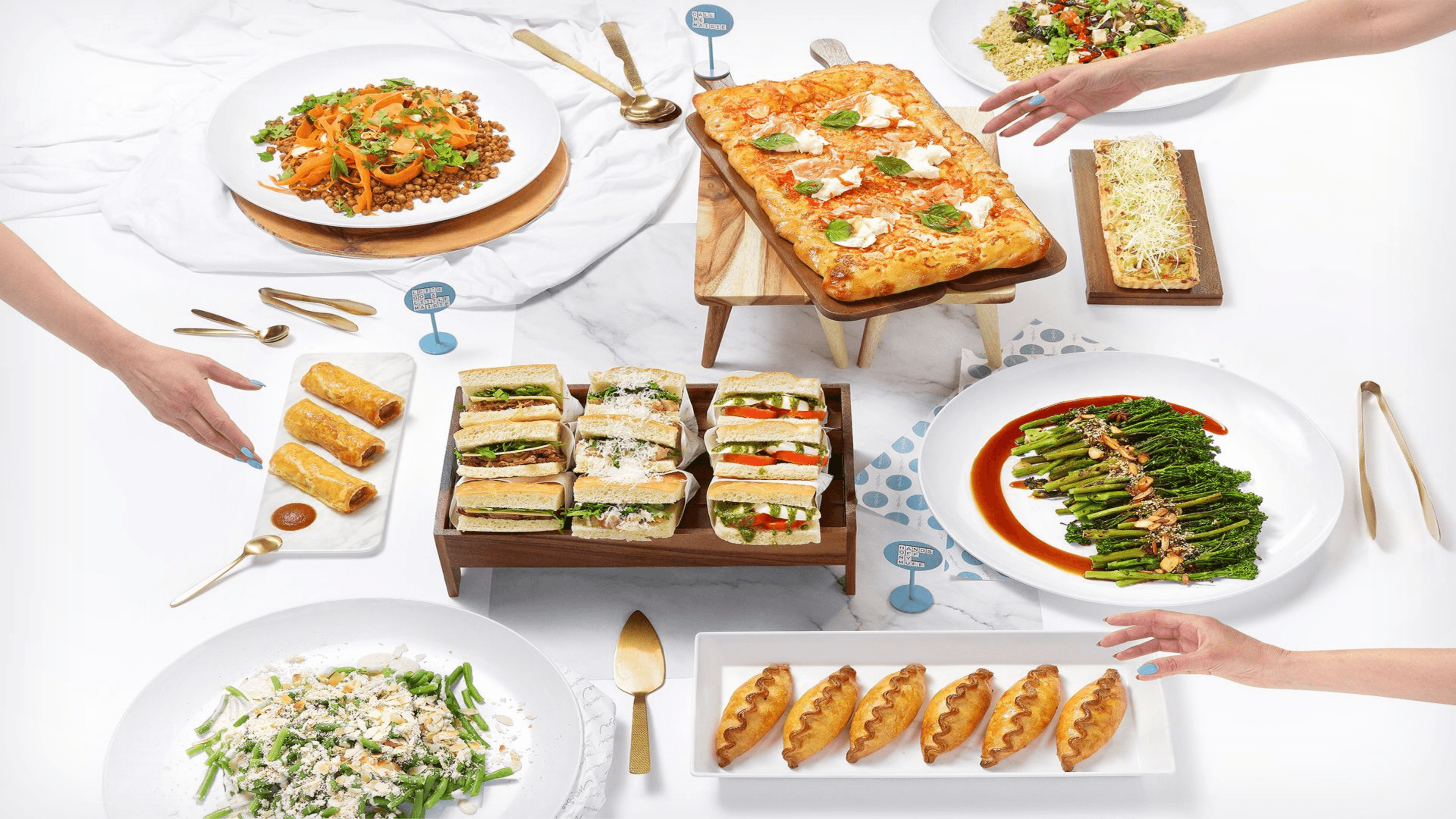 A Maisie catering spread, sandwiches, salads and fresh baking laid out to share