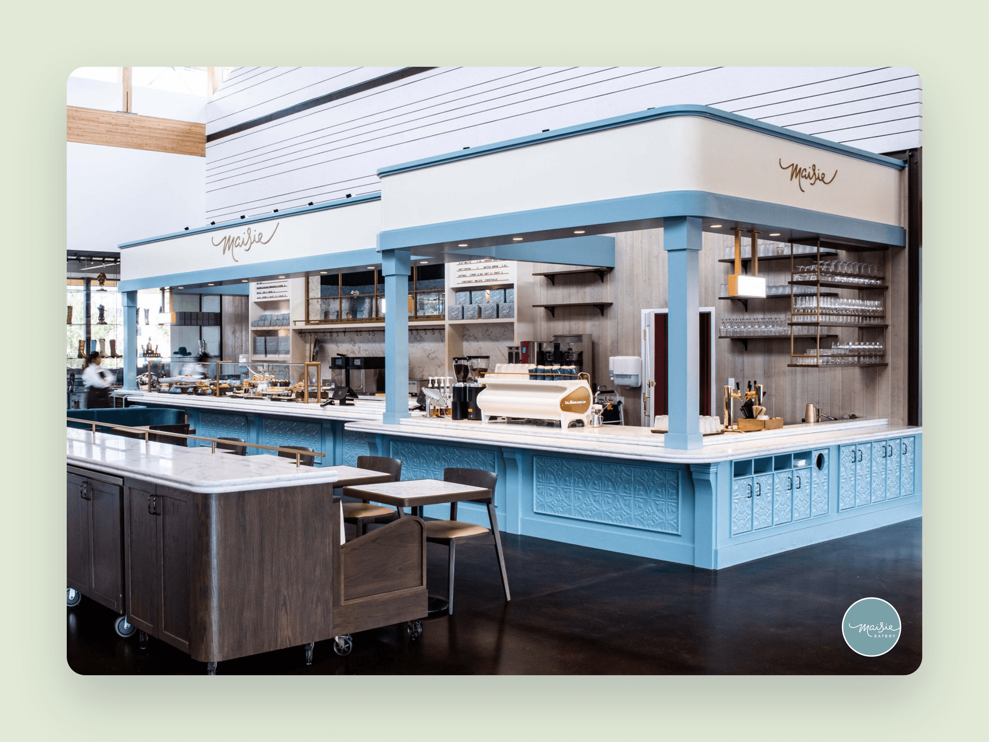 The Maisie Eatery counter inside the Sam Centre, soft blue millwork and the script mark overhead